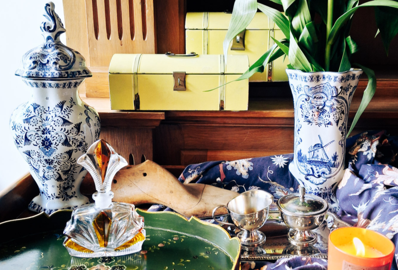 Decorative table setting with blue and white vases, a green tray, and a lit candle.